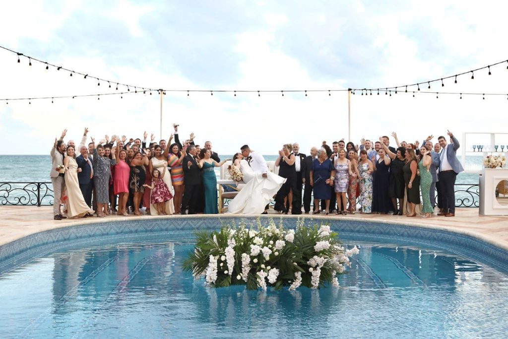 wedding guests photographed in front of the pool