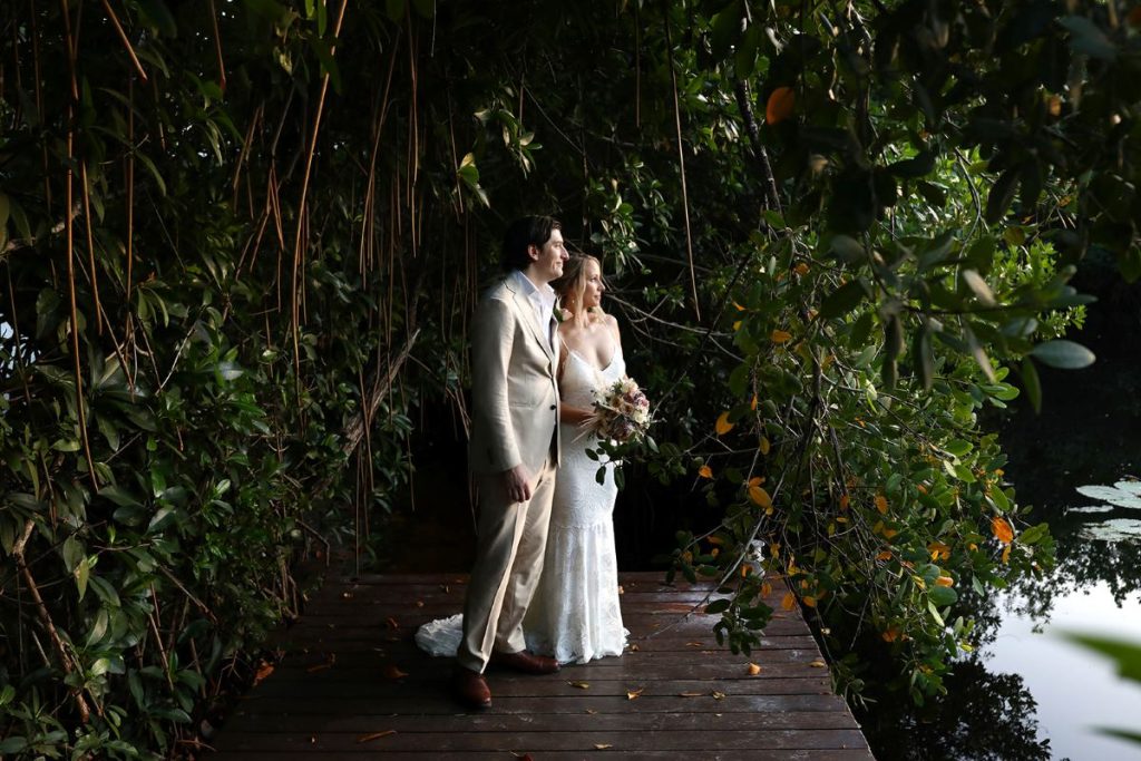 wedding couple posing for a photography in the middle of the mangroves at a luxury boutique resort in the riviera maya