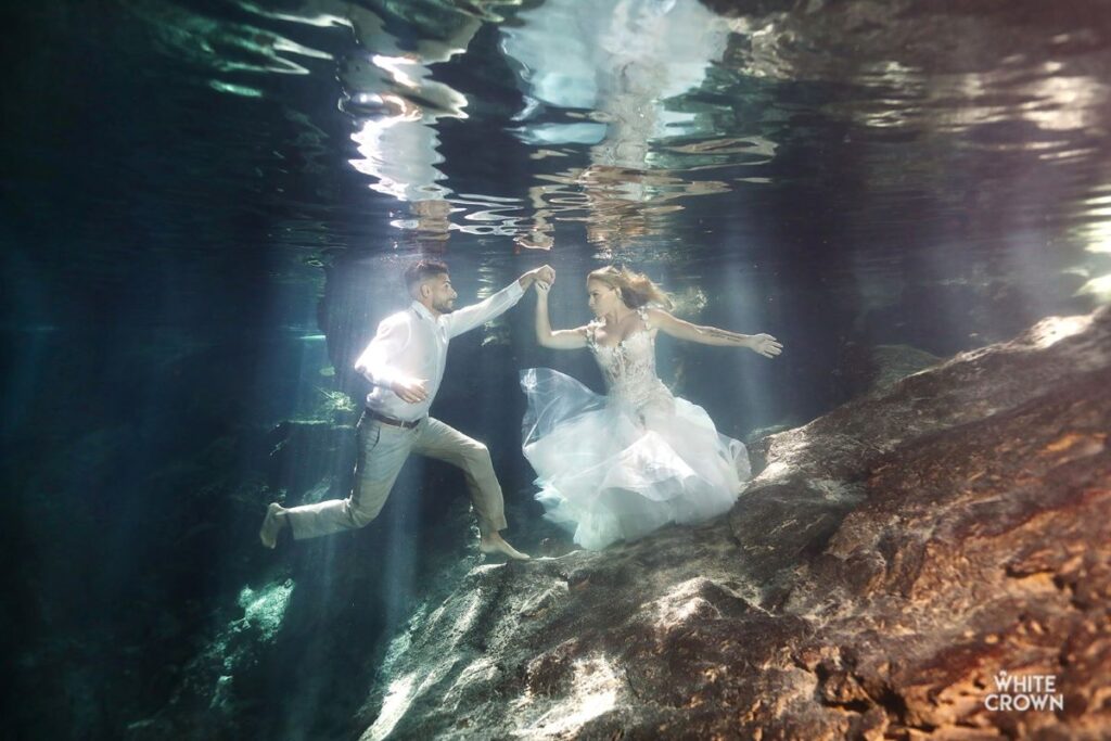 bride and groom during a trash the dress photo session in a cenote