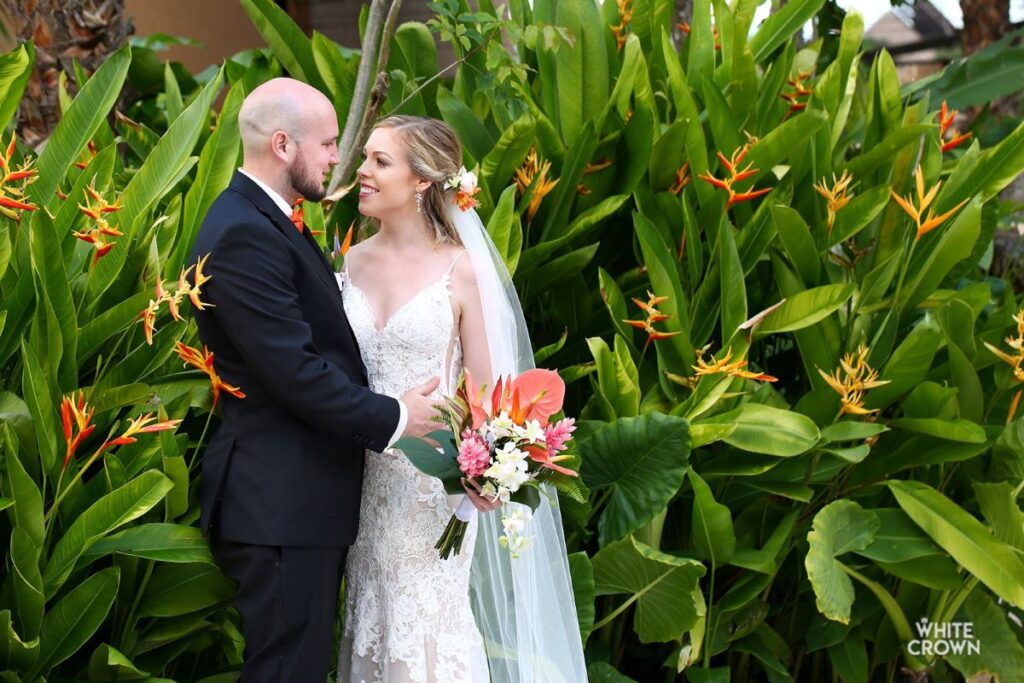 A wedding couple posing in a tropical garden at a beach resort in the riviera maya