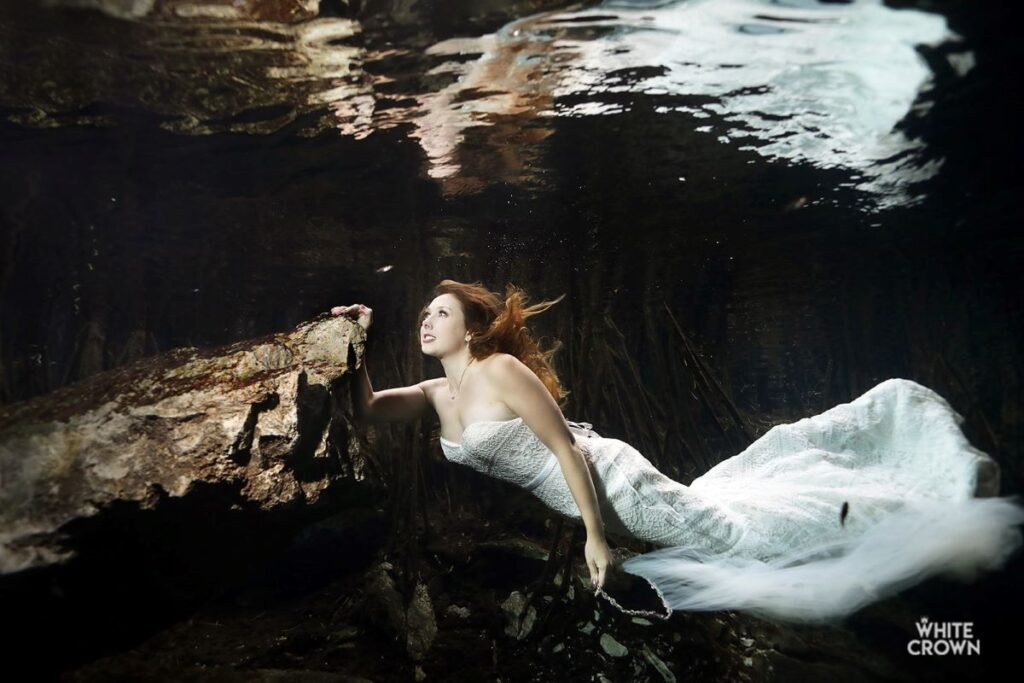 a stunning bride posing underwater for a photo session in cancun