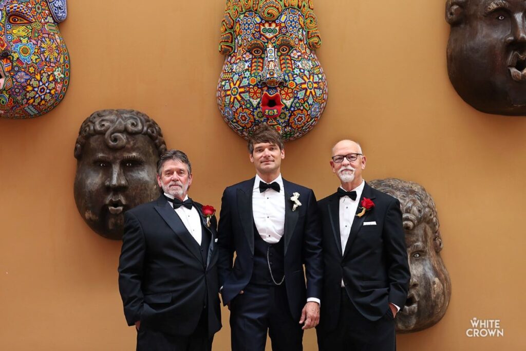 Groom posing with the father-in-law and his father for a picture before the wedding